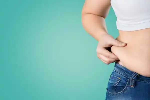 Image of woman pinching her love handles to show weight gain Milngavie